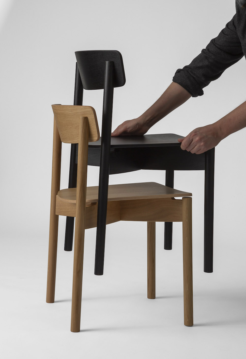 Demonstrating the stackable ability of the Cross Chair