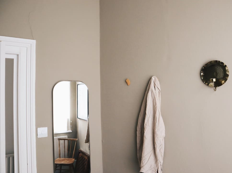 A bedroom wall featuring a shade from COAT's neutrals collection